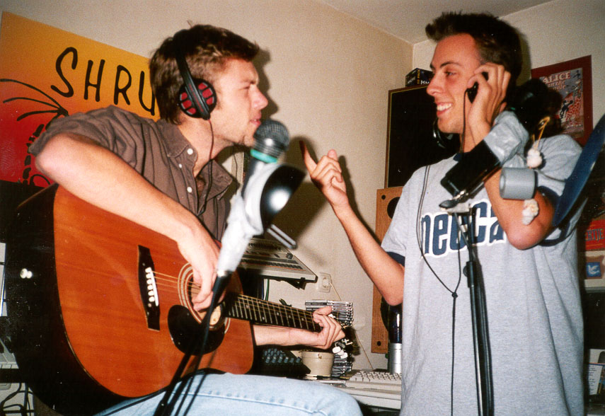 Rick and Iwan recording guitar and vocals with headphones on